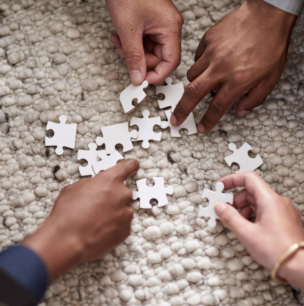 group of people fitting puzzle pieces together