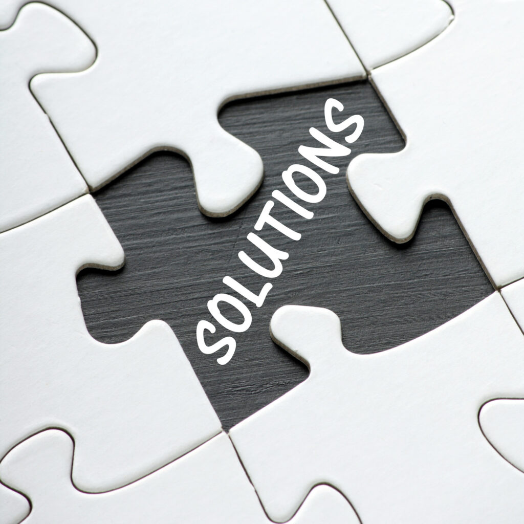 The word Solutions written in the space of a missing piece from a jigsaw puzzle as a concept for problem solving